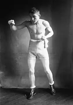 Photographie en noir et blanc d'un boxeur en garde à l'entraînement.