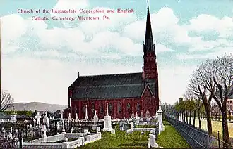 Au premier plan, le cimetière ; au deuxième, l’église. À droite, une large rue bordée d’arbres, avec de l’autre côté des habitations de faible hauteur. La légende, écrite en rouge sur les nuages et le ciel, indique, en anglais « Church of the Immaculate Conception and English Catholic Cemetery, Allentown, Pa. » (« Église de l’Immaculée-Conception et cimetière catholique anglais, Allentown, Pennsylvanie »).
