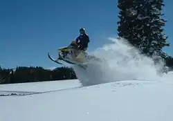 Photo d'un Ski-Doo sautant une dune de neige.