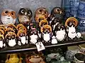 Des petites statuettes de tanuki en céramique de Shigaraki, accompagnées de chouettes.