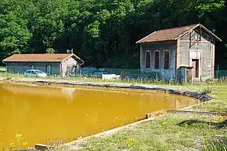 Le bassin de décantation et d'anciens bâtiments.