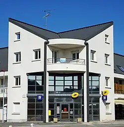 Bâtiment moderne à trois étages avec grande baie vitrée à l'entrée.