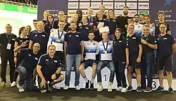 Photo de toute de l'équipe avec Élise au centre avec un cadeau dans les mains