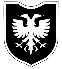 Un blason militaire représentant un aigle à deux têtes blanc sur fond noir.