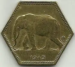 Une pièce jaune hexagonale avec le dessin d'un éléphant et la date 1943.