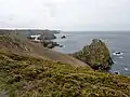 Les falaises entre Ménez Kermaden et la Pointe de Penharn, qui est visible à l'arrière-plan (celle-ci se trouve dans la commune de Cléden-Cap-Sizun).