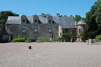 Vue d'un édifice à trois étages, couvert d'ardoise. À droite, une tour attenante.
