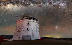 Vue en contre-plongée d'un bâtiment avec une coupole devant un ciel avec des milliers d'étoiles.