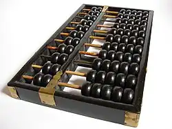 cadre de bois comportant plusieurs tiges parallèles sur lesquelles sont enfilées des boules noires