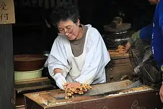 Fabrication de l'aburi-mochi dans l'Imamiya-jinja