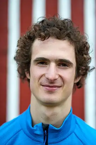 portrait d'un jeune homme blanc aux cheveux bruns bouclés