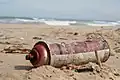 Cannette aérosol échouée sur une plage.