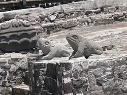 Deux crapauds stylisés, sculptés dans de la pierre grise