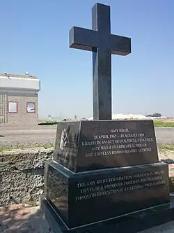 Monument en forme de croix chrétienne en granit gris foncé.