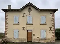 La façade principale de couleur beige d'un ancien bureau de poste.