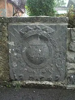 Pierre aux armes sculptés