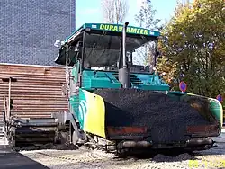 Finisseur en fonction, trémie ouverte.