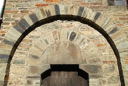 Tympan monolithique et arc en plein cintre sous un arc de décharge.