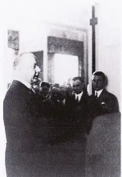 photographie en noir et blanc d'un groupe de personnes dans une pièce.