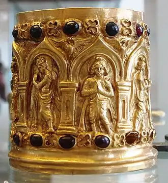 Reliquaire. Dévot, de face, et déités nimbées, de profil, en adoration. Or, grenats. Ier ou IIe&nbsp;siècle . British Museum