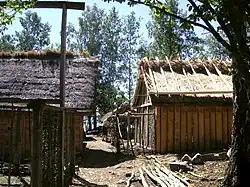 Photographie de deux bâtiments en matériaux naturels