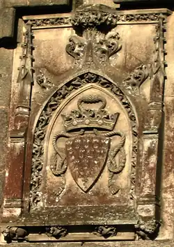 Vue d'un blason gravé sur une dalle de pierre verticale.