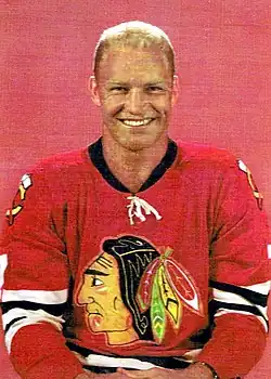 Photographie du joueur avec un maillot de hockey rouge floqué du logo des Black Hawks de Chicago