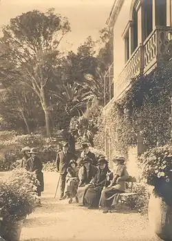  Paul Bourget au Plantier de Costebelle avec Henry Bordeaux et quelques amis, photo d'extérieur, certains sont assis sur un banc.