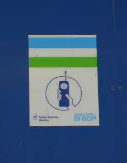 Photo : logo Bi-Bop bleu blanc vert au-dessus d'un symbole de téléphone tenu en main.