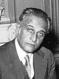 Un homme d'une cinquantaine d'années, en costume-cravate.