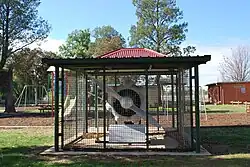Le moteur d'un Avro Anson dans une cage avec une plaque commémorative vu de devant.