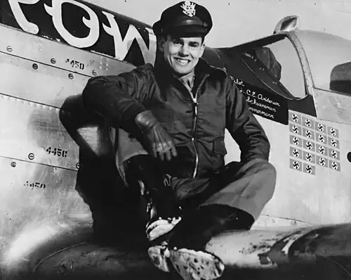 Le capitaine Clarence E. Jr. « Bud » Anderson, as du 357e groupe de chasse&nbsp;(en), est assis sur l’aile de son P-51 Mustang (B6-S, numéro de série 44-14450) surnommé « Old Crow ».