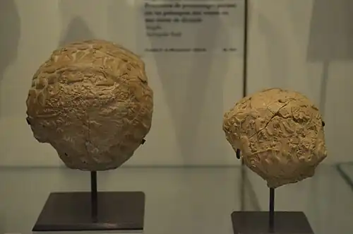 Deux bulles fragmentaires en argile, avec des motifs imprimés à leur surface.