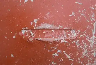 Estampille nominative imprimée au cachet sur le fond d'un vase.