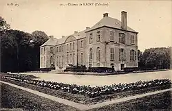Photographie en noir et blanc représentant une façade d'un château avec une cour munie de parterres fleuris