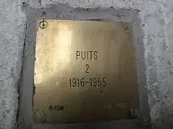 La plaque d'identification : « Puits 2, 1916-1955 ».