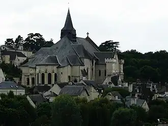Photographie en couleurs d'une église dans un village au flanc d'un coteau.