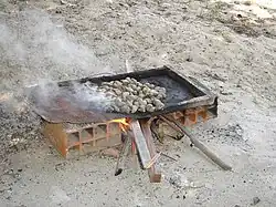 1. Les noix sont placées sur une tôle au-dessus d'un feu.