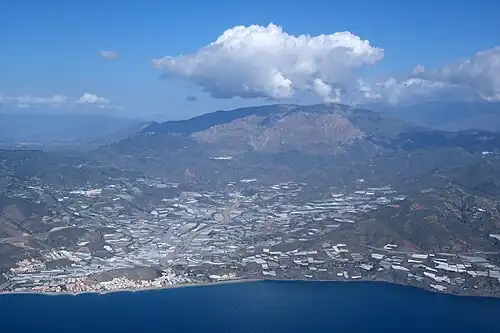 Vue plus générale, avec la commune de Lújar au centre, le village de Lújar au pied de la sierra de Lújar&nbsp;(es) au fond, et une partie de Rubite à droite