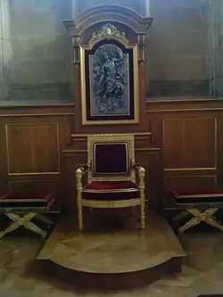 Cathèdre (fin du XVIIIe&nbsp;siècle) en bois doré et les deux tabourets assortis, avec derrière un panneau représentant le Christ revenant dans la gloire sur le cadre du lambris mouluré chêne et doré et deux consoles sur les côtés du panneau et à agrafe à coquille et rubans en haut.