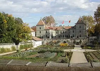 Photographie en couleur d'un château et de son jardin.