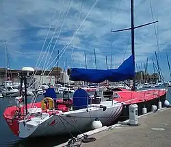 Vu de trois quarts arrière, bateau rouge et blanc, amarré au ponton.
