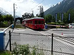 Train au passage à niveau jouxtant la gare.