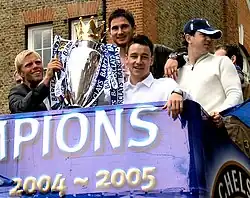 Frank Lampard, au deuxième étage d'un bus à toi ouvrant, tenant le trophée du championnat d'Angleterre en compagnie de John Terry et Eiður Guðjohnsen
