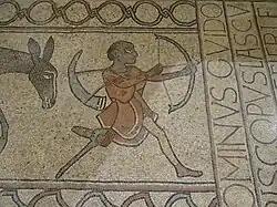 Photographie en couleurs d'une mosaïque représentant un chasseur unijambiste.