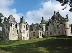 Photographie en couleurs d'un château avec de nombreuses tours et tourelles.