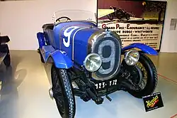 Photo d'une voiture bleue à carrosserie ouverte exposée dans un musée.