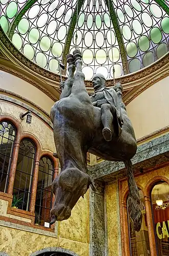 Statue provocante de David Černý dans le passage.
