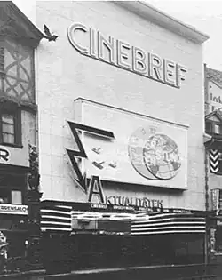 Photo noir et blanc de la façade avec une enseigne Cinébref en grandes lettres capitales et Aktualitätek sous un globe terrestre.