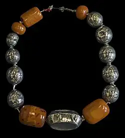 Collier en argent et pièces d'ambre polis (début du xxe&nbsp;siècle), muséum de Toulouse.